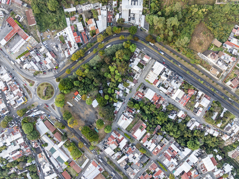 Aerial view of the urban layout of Uruapan featuring a roundabout dense residential buildings lush green trees and intersecting roads in Uruapan Michoacan Mexico. Aerial view of the urban layout of Uruapan featuring a roundabout dense residential buildings lush green trees and intersecting roads in Uruapan Michoacan Mexico.