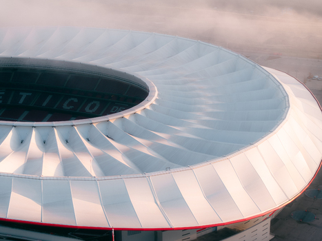 Aerial view of the Riyadh Air Metropolitano Stadium featuring its distinctive white tensile roof structure under soft morning light in Madrid Comunidad de Madrid Spain.