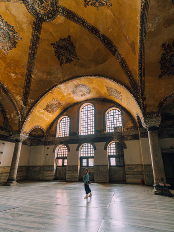 Istanbul Turkiye 07 October 2019 View of the grand historic interior of Hagia Sophia with its arched ceilings aged textures and a lone figure standing on the marble floor.