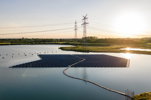Aerial view of floating solar panels on a lake with power lines at sunset in Bensheim Hessen Germany. Aerial view of floating solar panels on a lake with power lines at sunset in Bensheim Hessen Germany.