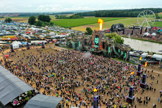 Herzogenaurach Germany 26 July 2025 Aerial view of Open Beatz Festival with a large crowd a main stage featuring fire effects and a ferris wheel in the background.