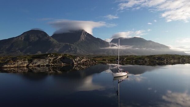 Aerial view of a sailboat on calm waters in Senja Norway. Aerial view of a sailboat on calm waters in Senja Norway.