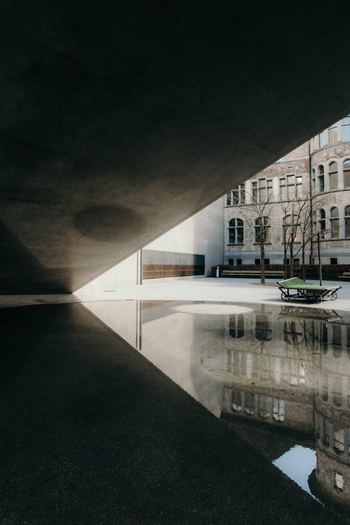 View of the museum s architecture reflected in a puddle creating a mirrored world where concrete meets historical facade Zurich Switzerland. View of the museum s architecture reflected in a puddle creating a mirrored world where concrete meets historical facade Zurich Switzerland.