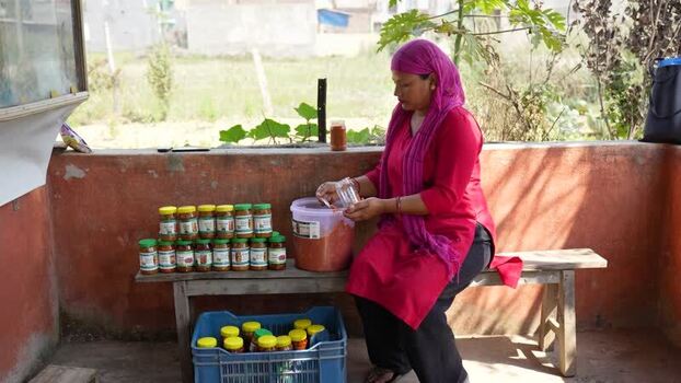 View of a woman preparing jars of pickles in Dhangadhi Nepal. View of a woman preparing jars of pickles in Dhangadhi Nepal.