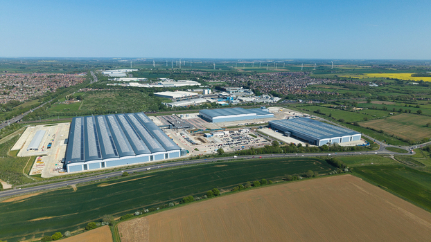 Aerial view of Symmetry Park industrial estate featuring large modern warehouses and parking facilities surrounded by green fields in Kettering England United Kingdom. Aerial view of Symmetry Park industrial estate featuring large modern warehouses and parking facilities surrounded by green fields in Kettering England United Kingdom.
