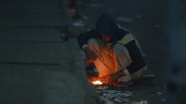 View of a person warming hands over a fire in Bogura Bangladesh. View of a person warming hands over a fire in Bogura Bangladesh.