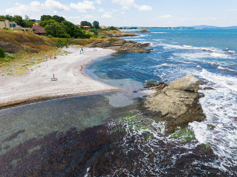 Aerial view of The clam beach with its rocky coastline clear blue waters and sandy shore surrounded by coastal greenery in Lozenets Burgas Bulgaria. Aerial view of The clam beach with its rocky coastline clear blue waters and sandy shore surrounded by coastal greenery in Lozenets Burgas Bulgaria.