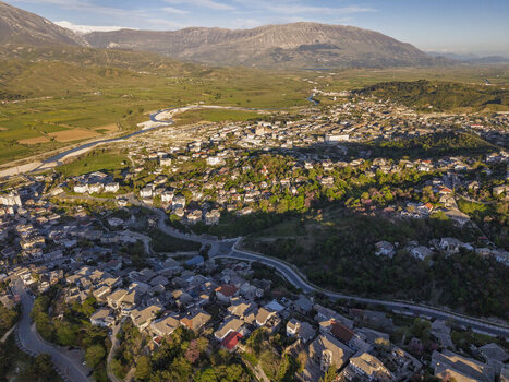 Aerial view of the historic stone architecture and traditional rooftops of the old town in Gjirokaster Gjirokaster County Albania. Aerial view of the historic stone architecture and traditional rooftops of the old town in Gjirokaster Gjirokaster County Albania.