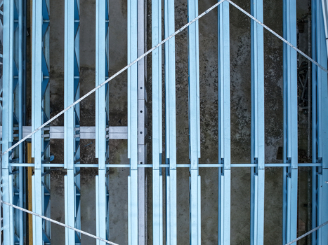 Aerial view of the structural steel framework of an industrial building under construction with parallel girders and metal beams in Melbourne VIC Australia.
