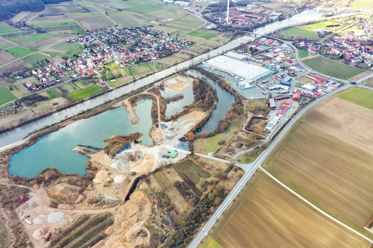 Aerial view of the town of Buttenheim showing the Main Danube Canal industrial buildings and residential houses surrounded by fields in Buttenheim Bavaria Germany. Aerial view of the town of Buttenheim showing the Main Danube Canal industrial buildings and residential houses surrounded by fields in Buttenheim Bavaria Germany.