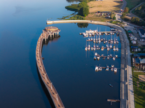Aerial view of the modern pier and marina with docked sailboats on the calm Vistula River in Plock Masovian Voivodeship Poland.