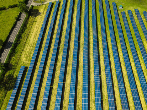 Aerial view of Lisburn Solar Farm with rows of photovoltaic panels set in green fields alongside a road in Lisburn Northern Ireland United Kingdom. Aerial view of Lisburn Solar Farm with rows of photovoltaic panels set in green fields alongside a road in Lisburn Northern Ireland United Kingdom.