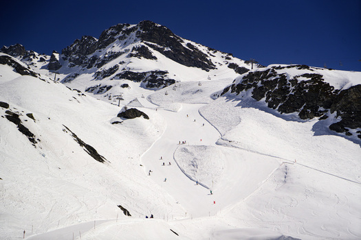 Aerial view of La Rosiere ski resort featuring snow covered slopes with skiers ski lifts and rugged mountain peaks under a clear blue sky in Montvalezan Auvergne Rhone Alpes France.