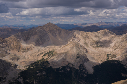 View of Huron Peak Mount Missouri in the Collegiate Peaks Wilderness rugged rocky slopes deep shadows from passing clouds and evergreen forests at the base in Buena Vista Colorado United States.