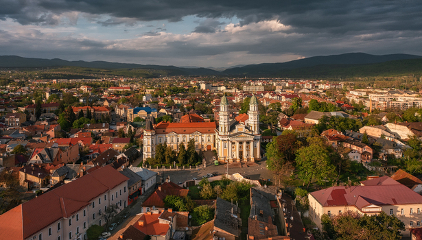 Aerial view of the grand Cathedral standing tall amidst a sea of red tiled roofs reflecting the golden light of the setting sun Uzhhorod Zakarpattia Oblast Ukraine. Aerial view of the grand Cathedral standing tall amidst a sea of red tiled roofs reflecting the golden light of the setting sun Uzhhorod Zakarpattia Oblast Ukraine.