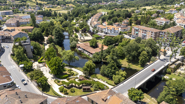 Aerial view of the river Arnoia flowing through the town with a park a bridge and residential buildings in Allariz Province of Ourense Spain. Aerial view of the river Arnoia flowing through the town with a park a bridge and residential buildings in Allariz Province of Ourense Spain.