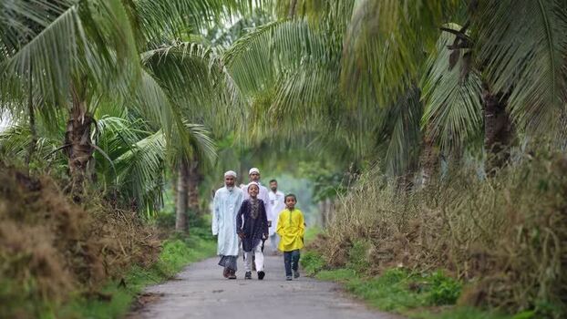 View of people walking on a path lined with palm trees Bangladesh. View of people walking on a path lined with palm trees Bangladesh.