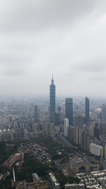Aerial view of Taipei 101 skyscraper surrounded by the dense urban skyline under an overcast sky Taipei Taiwan.