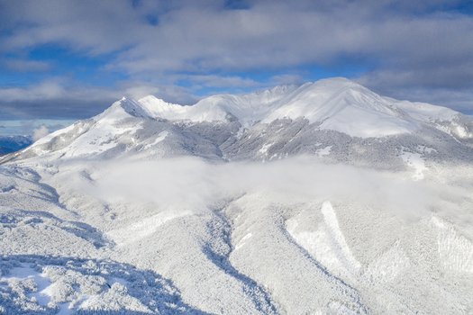 Aerial view of the snow covered peaks and frosted forests with a thick layer of clouds in the valley of Cerreto Laghi Emilia Romagna Italy. Aerial view of the snow covered peaks and frosted forests with a thick layer of clouds in the valley of Cerreto Laghi Emilia Romagna Italy.