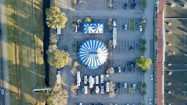 Aerial view of the circus tents with blue and white stripes surrounded by parked cars and RVs creating a vibrant scene St. Augustine Florida United States. Aerial view of the circus tents with blue and white stripes surrounded by parked cars and RVs creating a vibrant scene St. Augustine Florida United States.