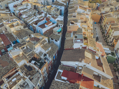 Aerial view of the colorful historic houses and narrow streets of the old town under warm sunlight in La Vila Joiosa Valencian Community Spain. Aerial view of the colorful historic houses and narrow streets of the old town under warm sunlight in La Vila Joiosa Valencian Community Spain.