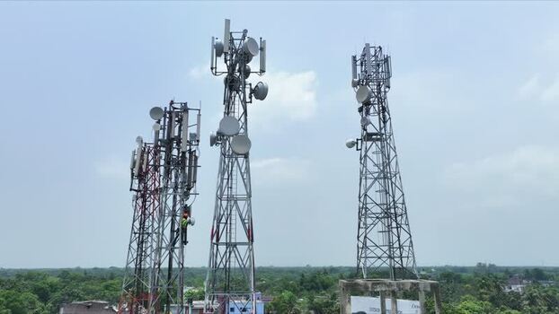 Aerial view of telecommunication towers with a technician climbing. Aerial view of telecommunication towers with a technician climbing.