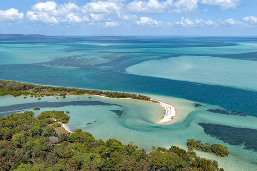Aerial view of Moreton Island featuring turquoise waters sandbanks and lush coastal vegetation under a bright blue sky in Kooringal Queensland Australia. Aerial view of Moreton Island featuring turquoise waters sandbanks and lush coastal vegetation under a bright blue sky in Kooringal Queensland Australia.