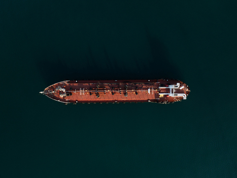 Aerial view of a large oil tanker ship with visible deck pipes and equipment on dark blue water in Augusta Sicily Italy. Aerial view of a large oil tanker ship with visible deck pipes and equipment on dark blue water in Augusta Sicily Italy.