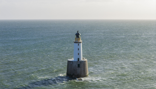 Aerial view of Rattray Head Lighthouse standing in the North Sea with gentle waves and a clear horizon near Peterhead Scotland United Kingdom. Aerial view of Rattray Head Lighthouse standing in the North Sea with gentle waves and a clear horizon near Peterhead Scotland United Kingdom.