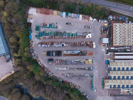 Aerial view of a sprawling industrial yard with organized stacks of materials contrasting against the surrounding green foliage Stoke on Trent United Kingdom. Aerial view of a sprawling industrial yard with organized stacks of materials contrasting against the surrounding green foliage Stoke on Trent United Kingdom.