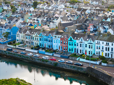 Aerial view of Bangor Harbour and Town with colorful terraced houses along the waterfront parked cars and calm water reflecting the architecture in Bangor Northern Ireland United Kingdom.