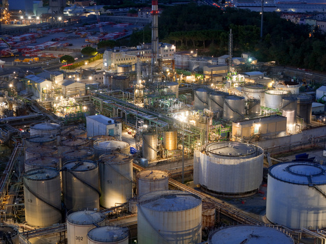 Aerial view of the plant for the production of finished lubricants illuminated at night with numerous storage tanks industrial pipes and infrastructure in Vado Ligure Liguria Italy. Aerial view of the plant for the production of finished lubricants illuminated at night with numerous storage tanks industrial pipes and infrastructure in Vado Ligure Liguria Italy.
