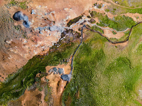 Aerial view of the geothermal landscape of Grensdalur with steaming vents colorful mineral deposits and vibrant green moss in Sveitarfelagid Olfus Iceland. Aerial view of the geothermal landscape of Grensdalur with steaming vents colorful mineral deposits and vibrant green moss in Sveitarfelagid Olfus Iceland.