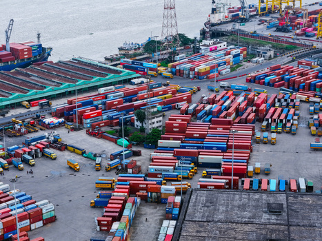 Aerial view of Chattogram Port featuring rows of colorful shipping containers cargo ships docked at the pier and industrial infrastructure in Chittagong Chittagong Division Bangladesh.
