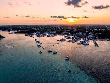 Aerial view of Club Nautico de Santo Domingo Inc. with boats in the marina at sunset featuring calm turquoise waters and a warm golden sky in Andres Santo Domingo Dominican Republic. Aerial view of Club Nautico de Santo Domingo Inc. with boats in the marina at sunset featuring calm turquoise waters and a warm golden sky in Andres Santo Domingo Dominican Republic.