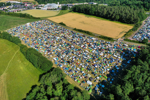 Aerial view of the Eventzentrum Strohofer Geiselwind musichall campsite with numerous colorful tents surrounded by lush green fields and dense forest in Geiselwind Bayern Germany. Aerial view of the Eventzentrum Strohofer Geiselwind musichall campsite with numerous colorful tents surrounded by lush green fields and dense forest in Geiselwind Bayern Germany.