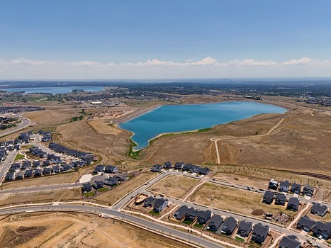Aerial view of the Leyden residential area featuring modern houses and a large reservoir under a clear blue sky in Jefferson County Colorado United States. Aerial view of the Leyden residential area featuring modern houses and a large reservoir under a clear blue sky in Jefferson County Colorado United States.