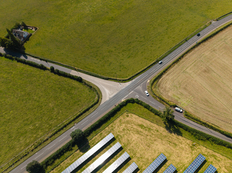 Aerial view of Lisburn Solar Farm with rows of solar panels green fields and a road intersection in Lisburn Northern Ireland United Kingdom. Aerial view of Lisburn Solar Farm with rows of solar panels green fields and a road intersection in Lisburn Northern Ireland United Kingdom.