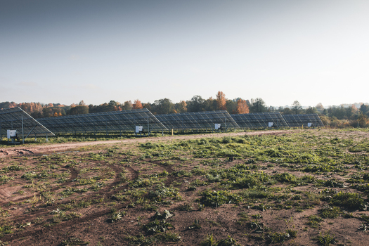 View of solar panels installed in a field with autumn trees in the background in Tartu County Estonia. View of solar panels installed in a field with autumn trees in the background in Tartu County Estonia.