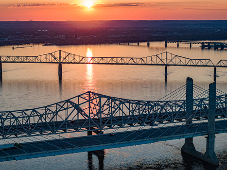 Aerial view of the Abraham Lincoln Bridge and John F. Kennedy Memorial Bridge spanning the Ohio River during a vibrant sunset in Louisville Kentucky United States. Aerial view of the Abraham Lincoln Bridge and John F. Kennedy Memorial Bridge spanning the Ohio River during a vibrant sunset in Louisville Kentucky United States.