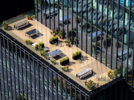 Aerial view of a modern office building terrace with wooden decking outdoor tables and potted plants in Katowice Silesian Voivodeship Poland. Aerial view of a modern office building terrace with wooden decking outdoor tables and potted plants in Katowice Silesian Voivodeship Poland.