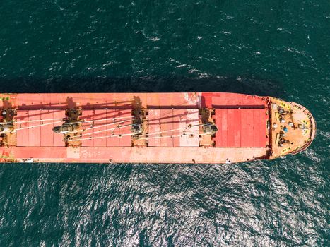 Aerial view of a large red cargo ship navigating the deep blue waters of the Black Sea with sunlight reflecting on the surface Varna Varna Bulgaria. Aerial view of a large red cargo ship navigating the deep blue waters of the Black Sea with sunlight reflecting on the surface Varna Varna Bulgaria.