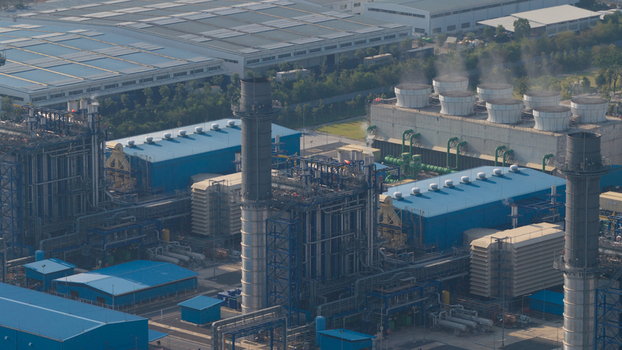 Aerial view of a large industrial power plant featuring cooling towers tall chimneys and blue roofed warehouses Map Yang Phon Rayong Thailand. Aerial view of a large industrial power plant featuring cooling towers tall chimneys and blue roofed warehouses Map Yang Phon Rayong Thailand.