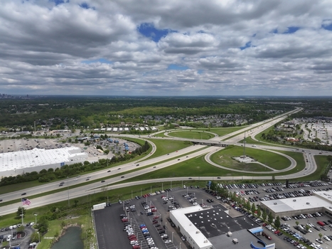Aerial view of a highway interchange with cloverleaf ramps large parking lots and commercial buildings under a cloudy sky in Columbus Ohio United States. Aerial view of a highway interchange with cloverleaf ramps large parking lots and commercial buildings under a cloudy sky in Columbus Ohio United States.