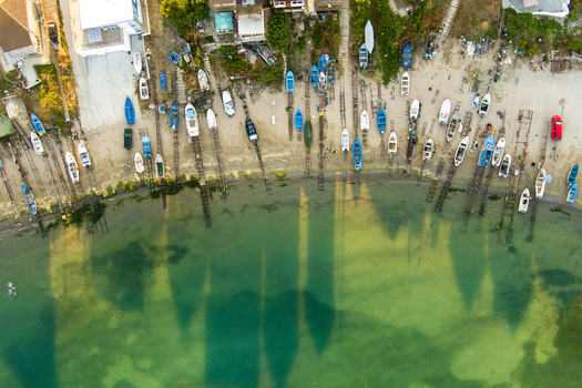 Aerial view of small fishing boats lined up on wooden tracks along the sandy shore at the resort of Saints Constantine and Helena Varna Bulgaria.