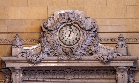 View of the ornate stone clock with intricate floral carvings inside Grand Central Terminal in New York New York United States. View of the ornate stone clock with intricate floral carvings inside Grand Central Terminal in New York New York United States.