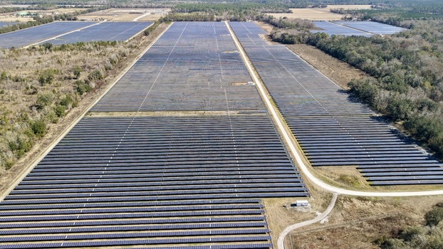 Aerial view of solar panels reflecting the sky s hue contrasting with the surrounding earth tones Elkton Florida United States. Aerial view of solar panels reflecting the sky s hue contrasting with the surrounding earth tones Elkton Florida United States.