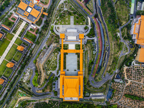 Aerial view of a traditional temple complex with vibrant orange roofs expansive courtyards and manicured gardens in Jiuru Township Pingtung County Taiwan. Aerial view of a traditional temple complex with vibrant orange roofs expansive courtyards and manicured gardens in Jiuru Township Pingtung County Taiwan.