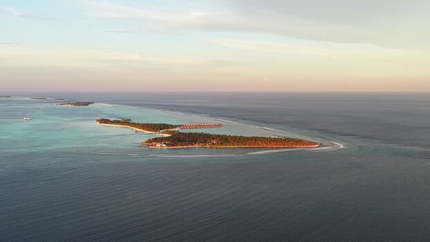 Aerial view of a tropical island resort at sunset Maldives. Aerial view of a tropical island resort at sunset Maldives.