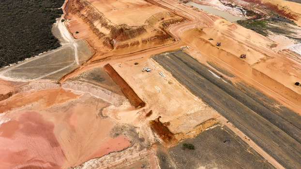 Aerial view of an industrial salt mining site featuring vibrant red sand textured salt extraction ponds and heavy machinery operating in Kalbarri Western Australia Australia. Aerial view of an industrial salt mining site featuring vibrant red sand textured salt extraction ponds and heavy machinery operating in Kalbarri Western Australia Australia.